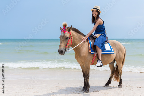 Beautiful Woman riding horse in sand beach