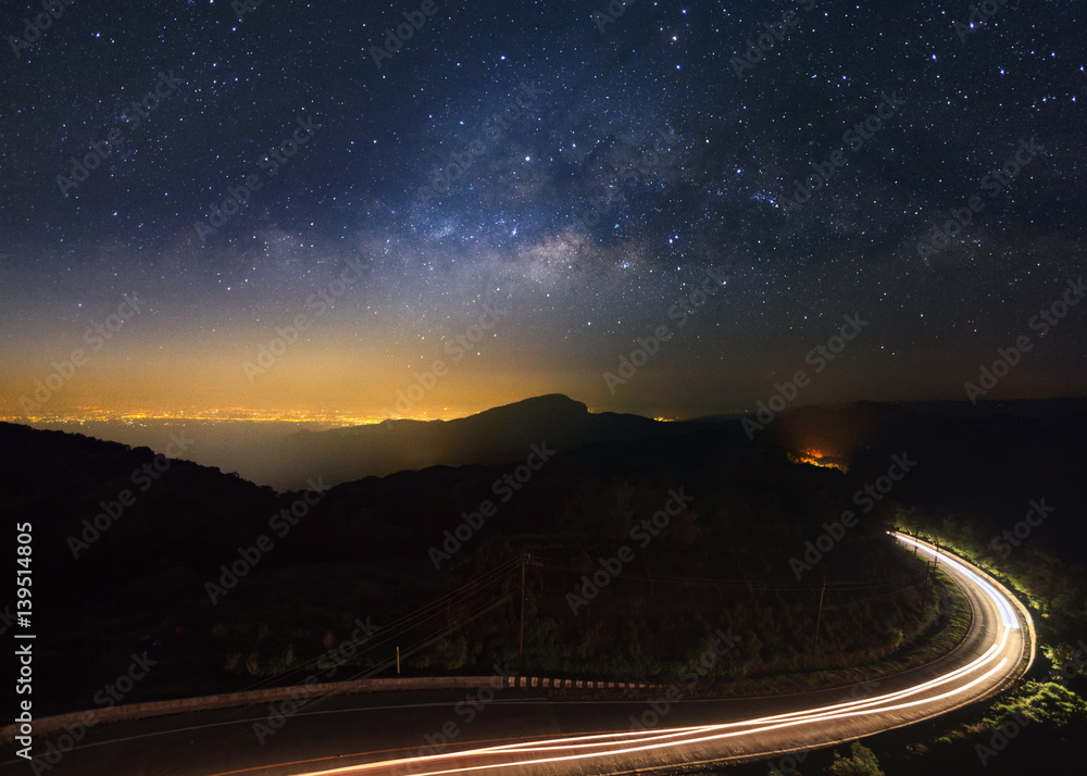 Naklejka premium Milky Way Galaxy with lighting on the road at Doi inthanon Chiang mai, Thailand.Long exposure photograph.With grain