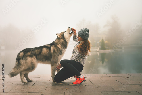 Bilde på lerret Image of young girl with her dog, alaskan malamute, outdoor