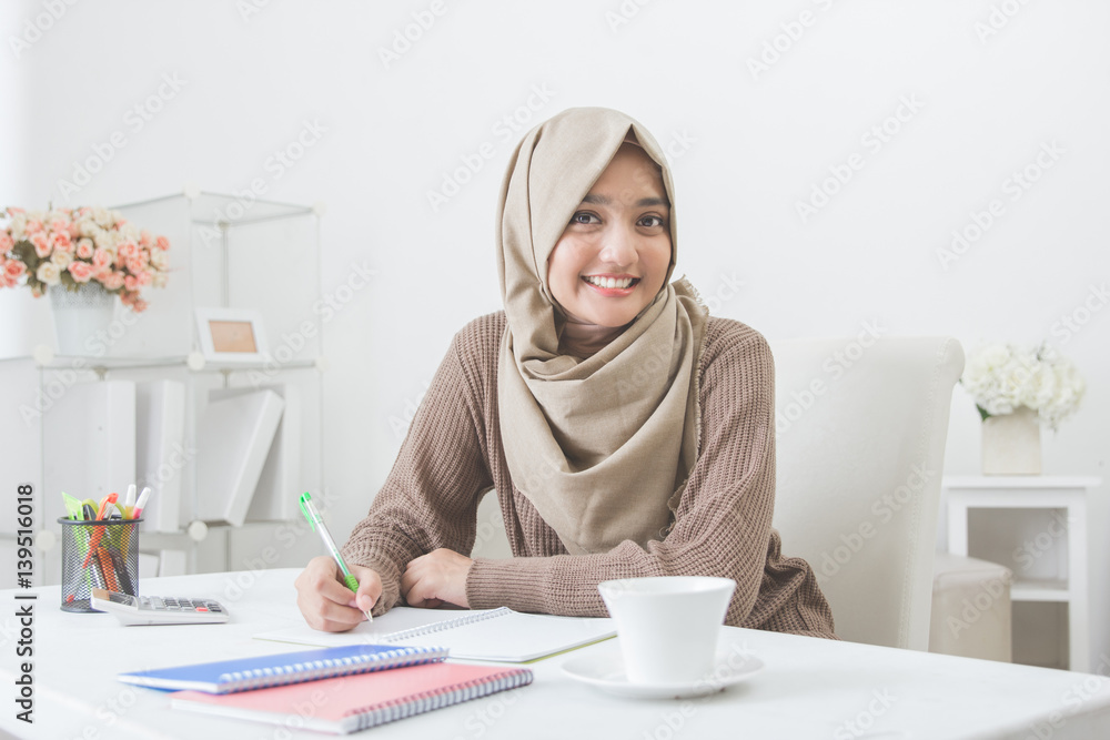 beautiful female asian student with hijab doing homework beautiful female asian student with hijab doing homework