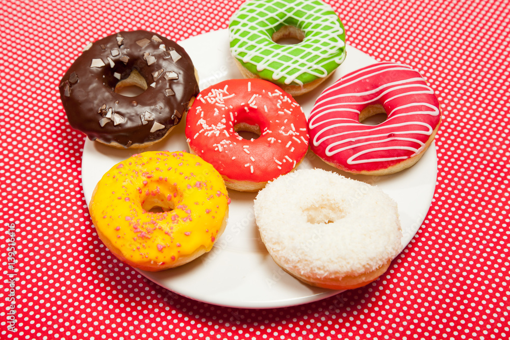 Colorful donuts on a red table