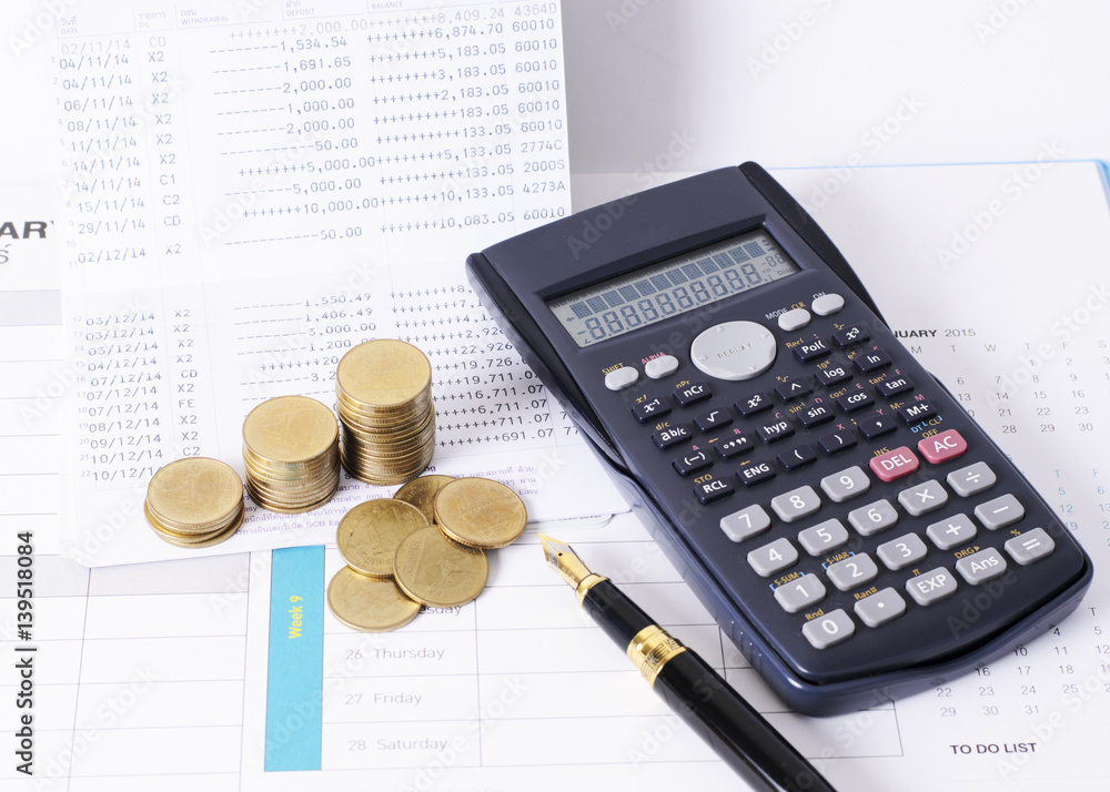 Calculator and money coins stack with fountain pen for finance concept Calculator and money coins stack with fountain pen for finance concept