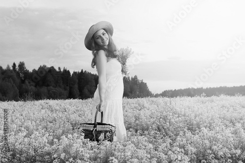 monochrome portrait of young girl in a hat standing in a huge field of flowers