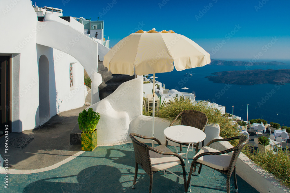Obraz premium Architecture of island of Santorini, the most romantic island in the world, Greece. Hotels in Santorini. Walking the streets of Fira summer day, Travel to Greece. Beautiful white exterior Santorini