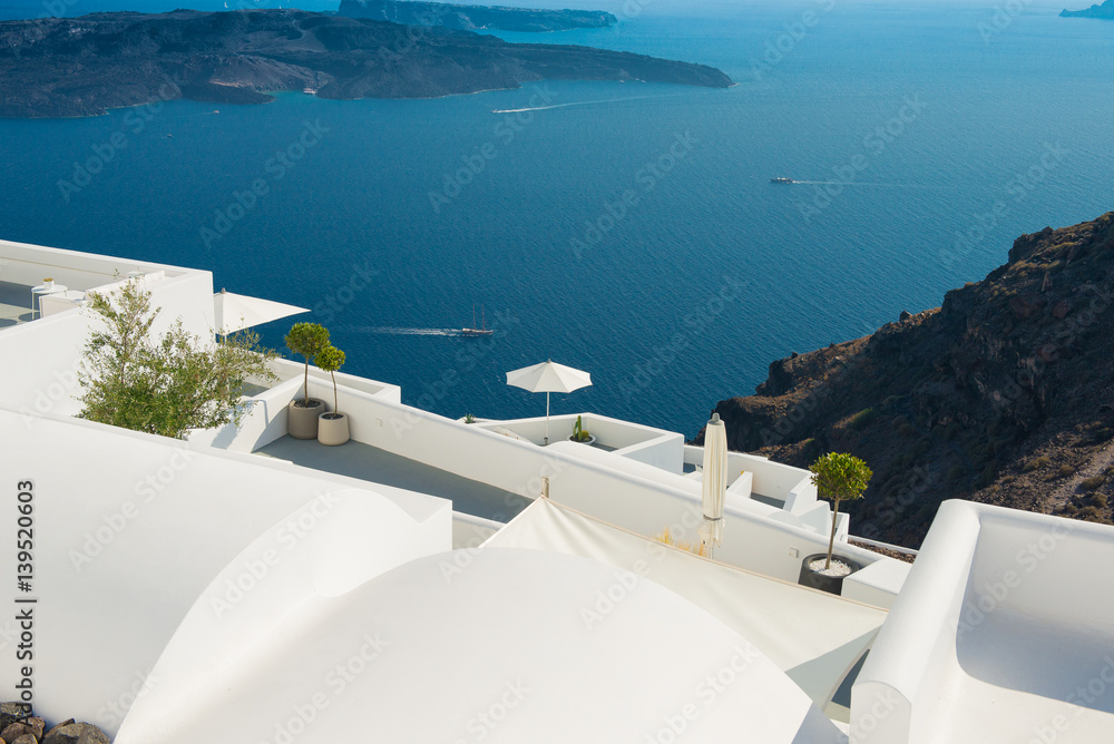 Obraz premium Architektura wyspy Santorini, najbardziej romantycznej wyspy na świecie, Grecja. Hotele w Santorini. Spacerując ulicami Firy w letni dzień, Podróż do Grecji. Piękny biały na zewnątrz Santorini