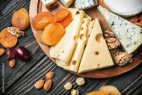 Fototapeta Naklejka Na Ścianę i Meble -  Assorted cheeses with nuts and dried fruits on the table