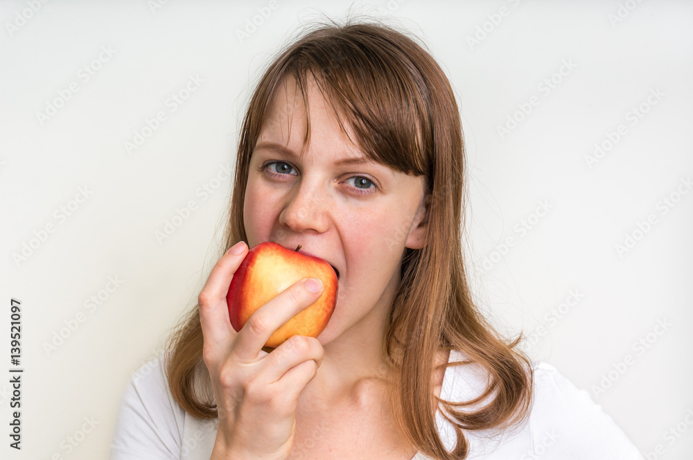 Woman eating an apple isolated on white Woman eating an apple isolated on white