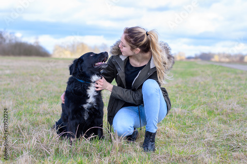 Loving young woman with her loyal black dog