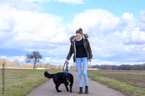 Young female student enjoying a run with her dog
