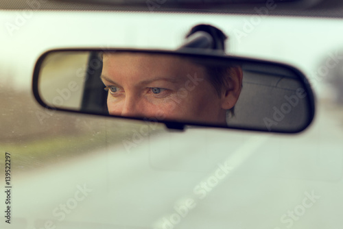 Female eyes focusing on road, reflection in vehicle rearview mirror © Bits and Splits