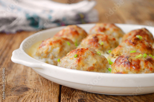 Meatballs in a white sauce. Food Photography. Wooden background.