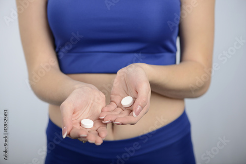 Sport and diet concept - woman with vitamins and medication.