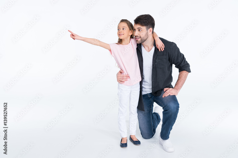 Happy father and cute little daughter pointing away with finger on white Happy father and cute little daughter pointing away with finger on white