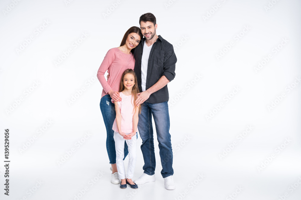Happy young family with one child standing together on white Happy young family with one child standing together on white