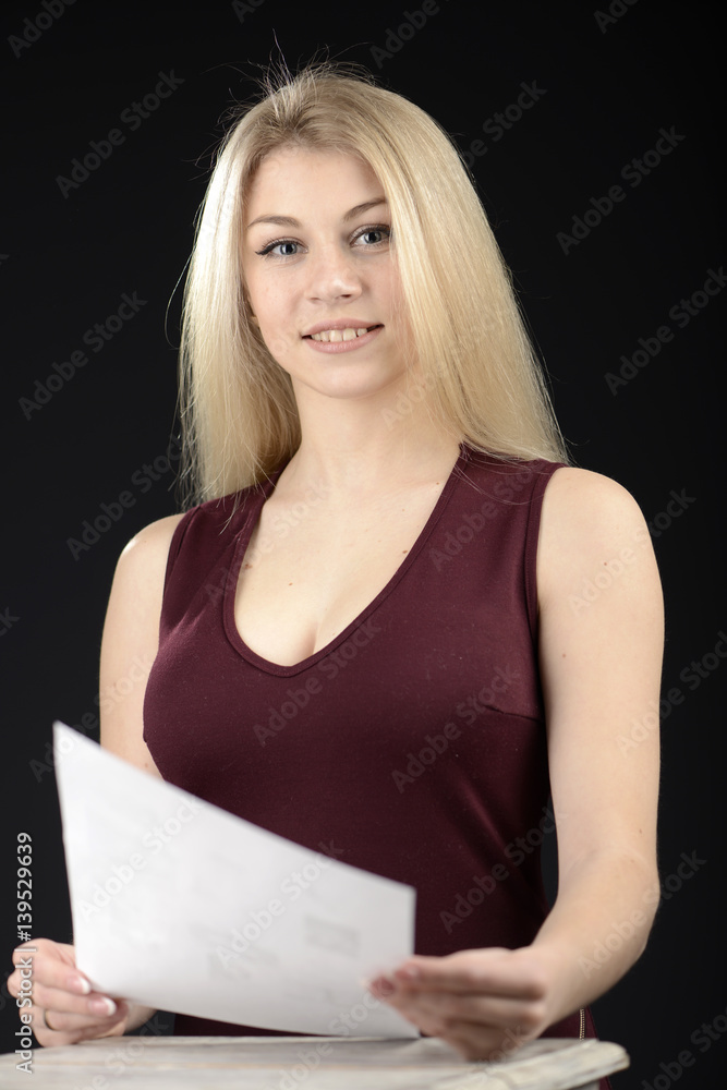 Attractive smiling young woman reading a paper Attractive smiling young woman reading a paper