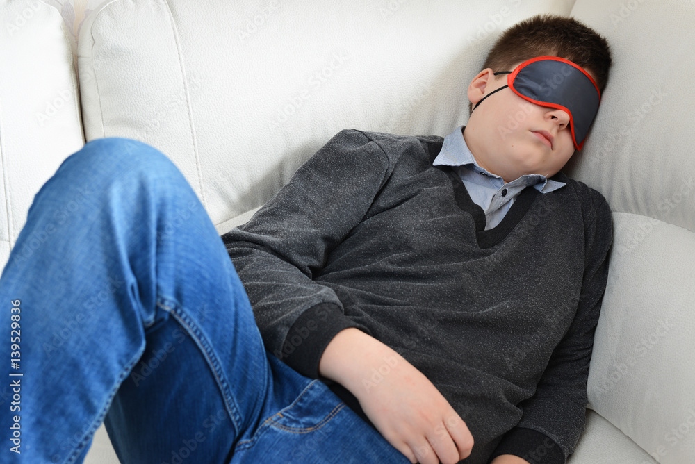 Teen sleeps during the day in mask for sleep Teen sleeps during the day in mask for sleep