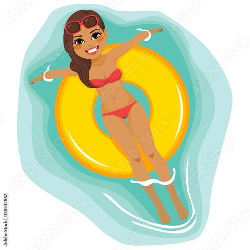 Beautiful brunette woman floating on big yellow inflatable ring tube on water