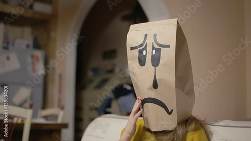 A depressed female breadbag face at home on the sofa, closing himself to the rest of the world.
 photo