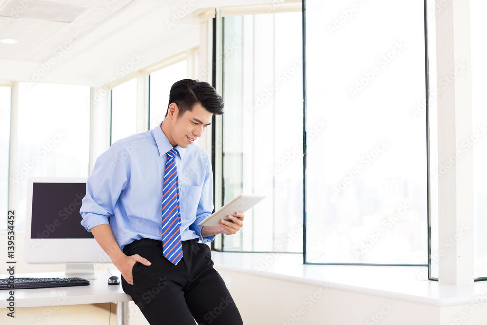 young Businessman with Digital Tablet in Office