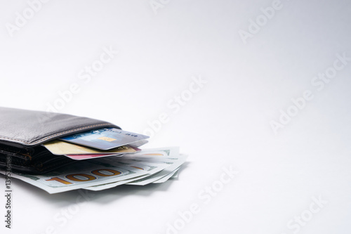Brown leather wallet with credit, debit, discount cards and dollars isolated on white background with copy space.