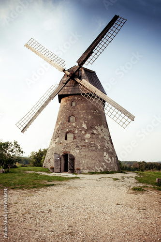Traditional Old dutch windmill in Latvia against blue sky with white clouds