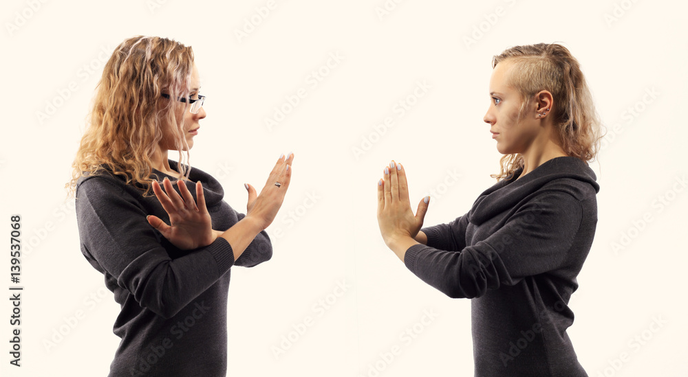 Self talk concept. Young woman talking to herself, showing gestures. Double portrait from two different side views.