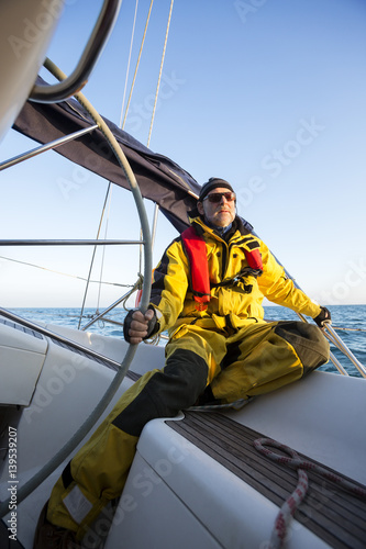 Mature Man Holding Wheel Of Sail Boat