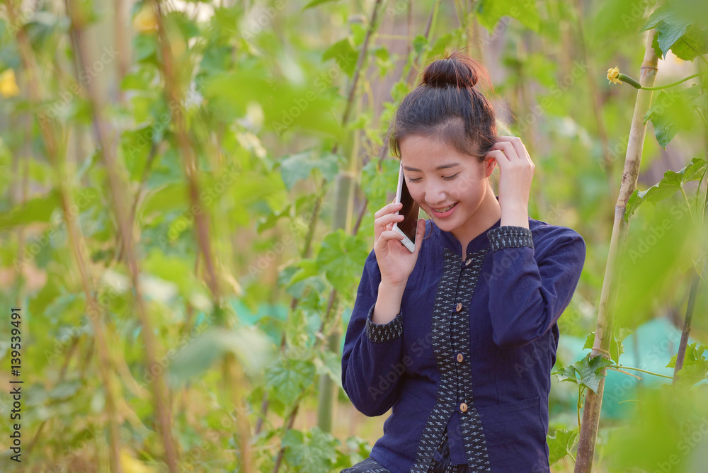 The girl is happy using the telephone outdoors. The girl is happy using the telephone outdoors.
