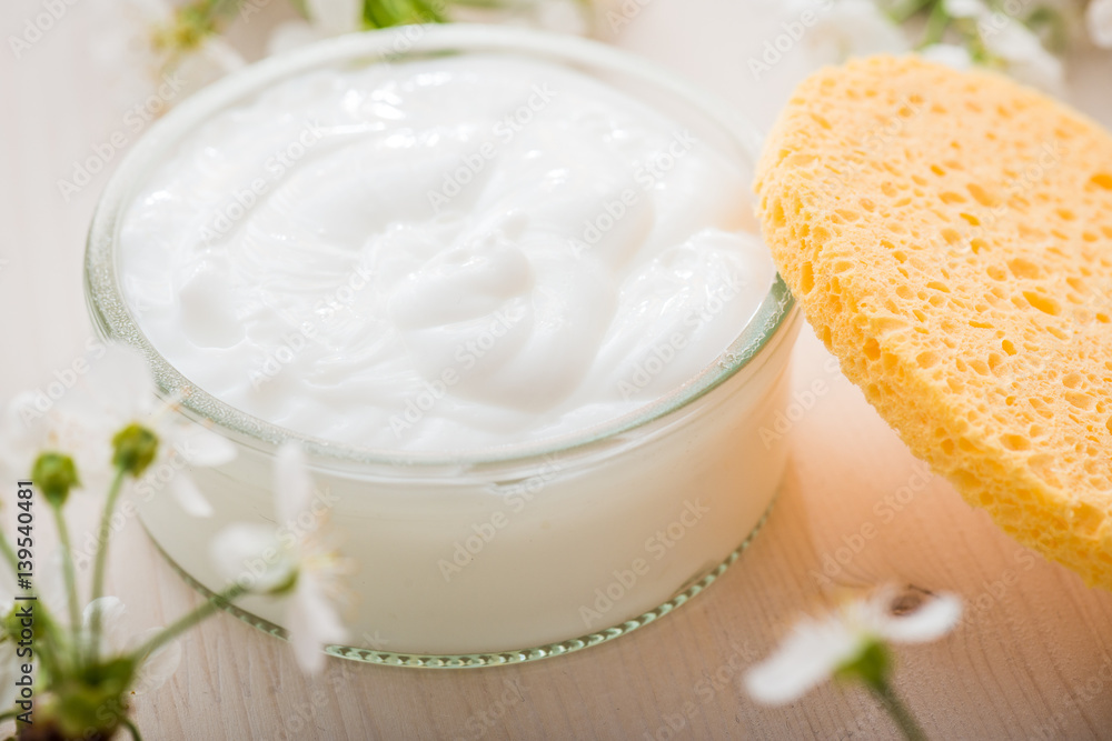 Face cream with spring flowers on white background Face cream with spring flowers on white background