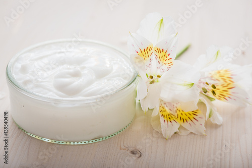 Face cream with spring flowers on white background