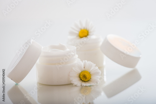 Face cream with spring flowers on white background