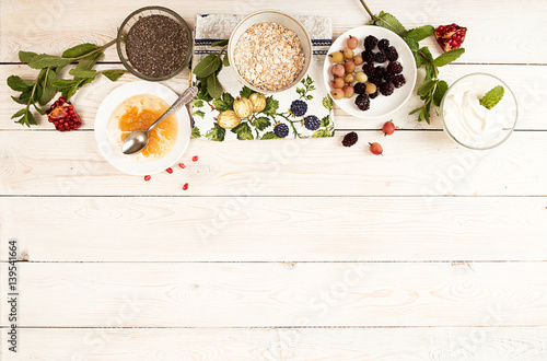 Ingredient for preparing healthy breakfast: chia, muesli, frozen berries, yogurt