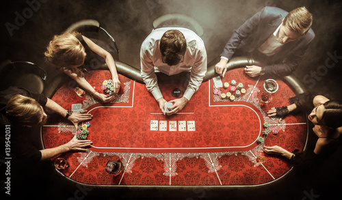 Fotografia top view of men and women playing poker in casino