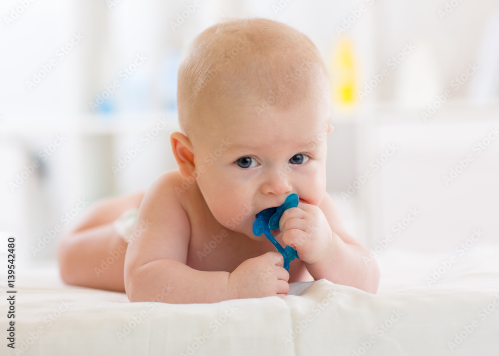 baby child lying on belly weared diaper with teether baby child lying on belly weared diaper with teether