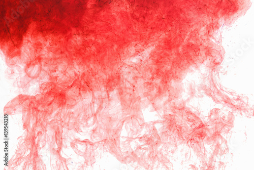 Abstract background. Red ink in water, in motion. Color drop swirling. Colorful cloud of paint on white.