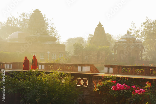 Indian women in sari at Mandor Gardens in the early foggy morning, among old Hindu Royal Cenotaphs 17 century of  Maharajas in Jodhpur, Rajasthan, India.