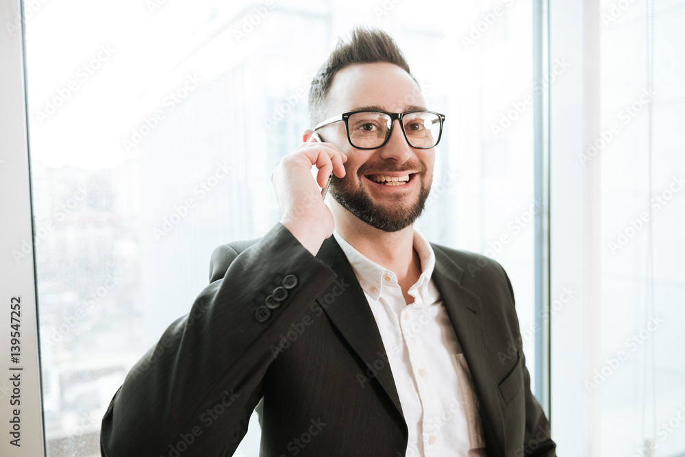 Smiling Bearded business man talking on phone Smiling Bearded business man talking on phone