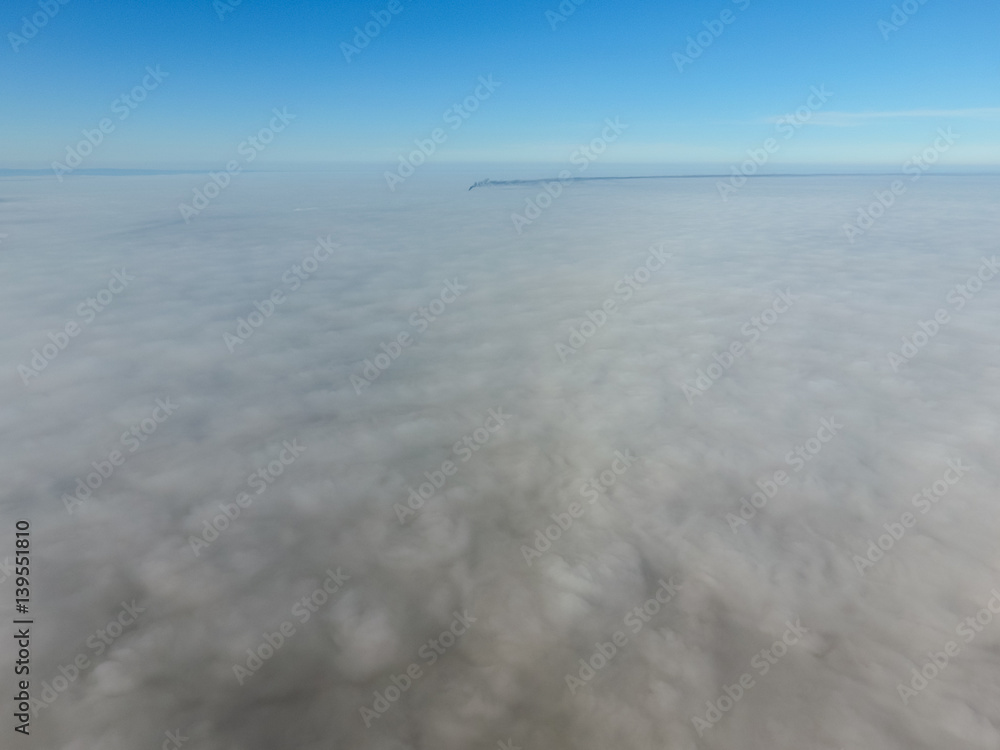 In the skies above the fog. Sunrise over the fog. Clouds near the ground In the skies above the fog. Sunrise over the fog. Clouds near the ground