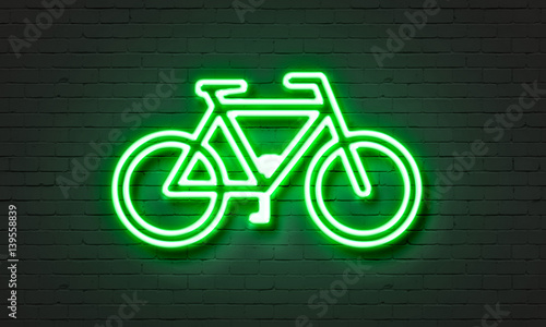 Bike icon neon sign on brick wall background. photo