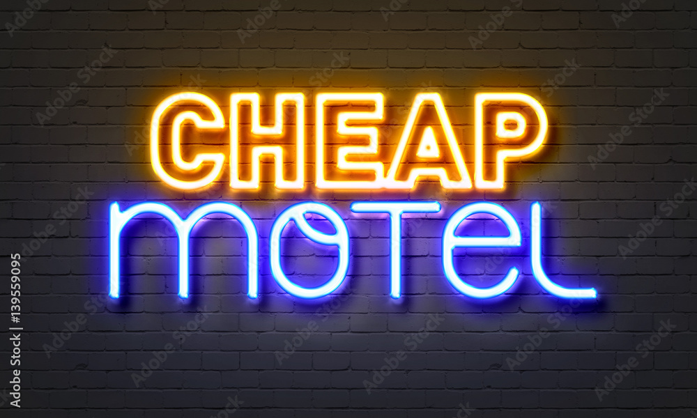 Cheap motel neon sign on brick wall background.