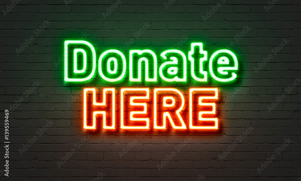 Fototapeta premium Donate here neon sign on brick wall background.