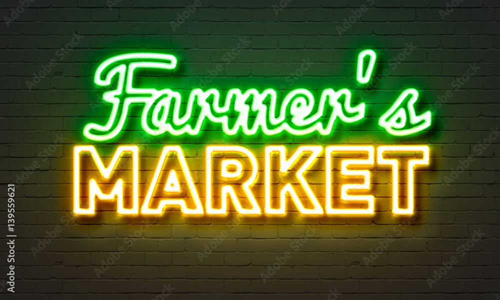 Farmers market neon sign on brick wall background.