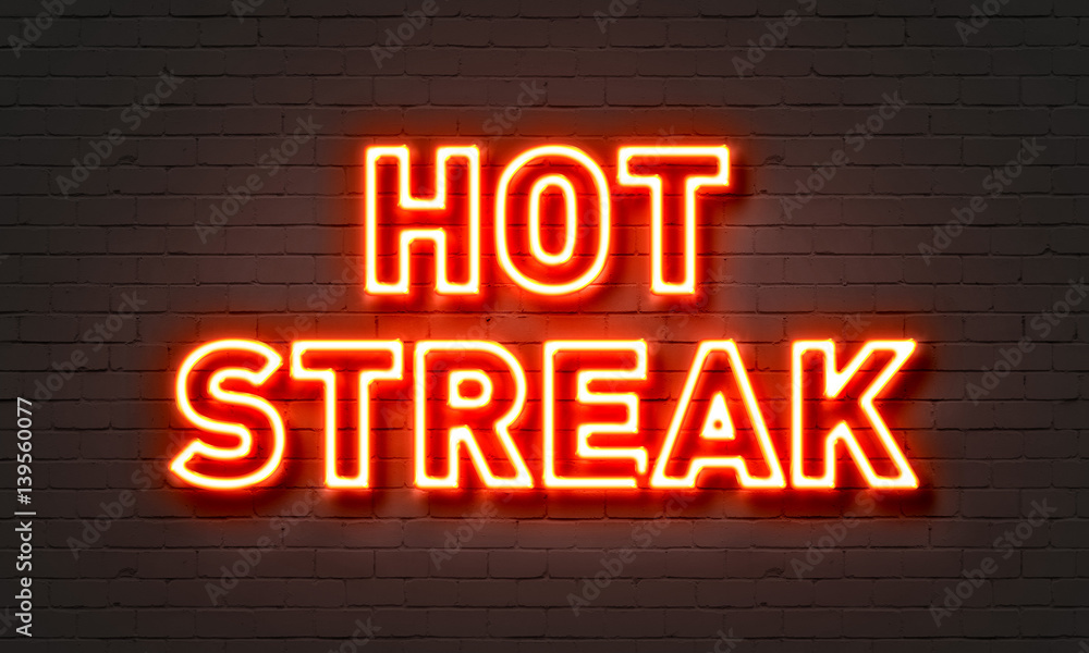 Hot streak neon sign on brick wall background.