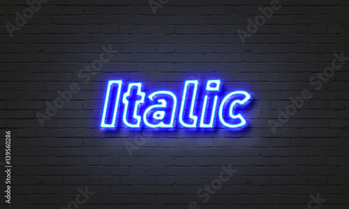 Italic neon sign on brick wall background.