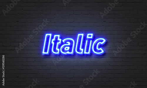 Italic neon sign on brick wall background. photo