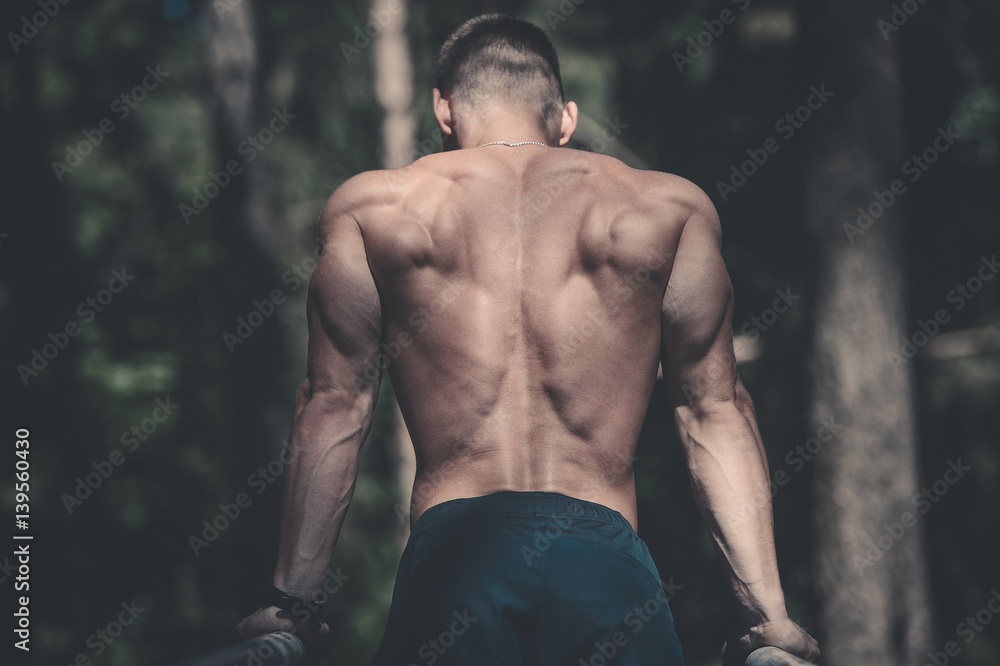 Fototapeta premium man doing exercises in outdoor gym naked torso.