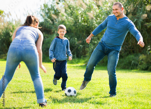 Portrait of active family playing soccer