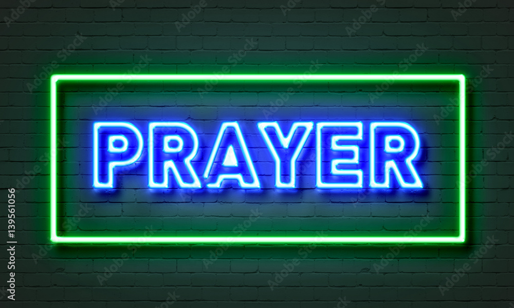 Prayer neon sign on brick wall background.