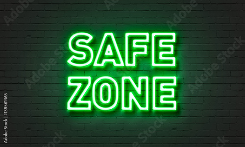 Safe zone neon sign on brick wall background.