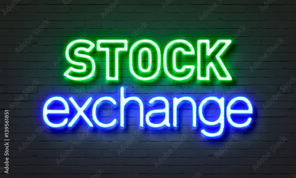 Stock exchange neon sign on brick wall background.